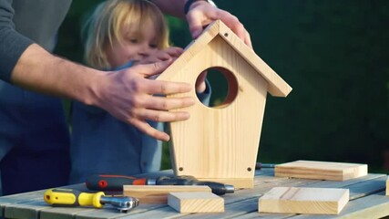 Father and son building birdhouse together, creative backyard project - Powered by Adobe