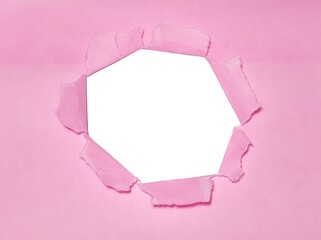 Torn hole on pink paper on smooth white background. Sheet of pink torn paper with blank space for text. Torn ripped recycle for advertising content promotion and advertising design.