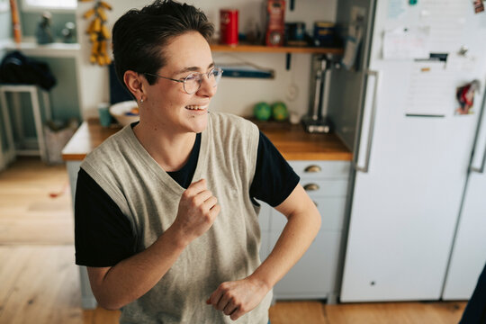 Happy young man enjoying leisure time dancing at home