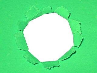 Torn hole on green paper on smooth white background. Sheet of green torn paper with blank space for...