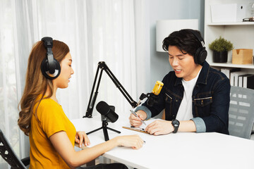 Smiling radio influencer host wearing headphone interviewing woman speaker sharing information to...