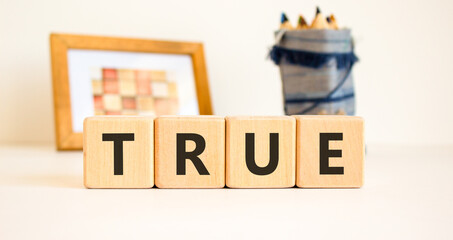True symbol. Concept word True on beautiful wooden blocks. Beautiful picture frame and colored...