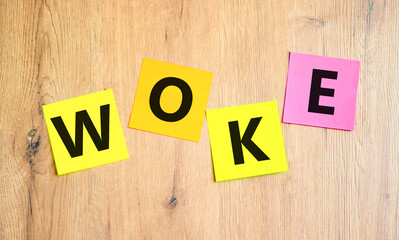 Woke question symbol. Concept word Woke question on beautiful colored paper. Beautiful wooden table...