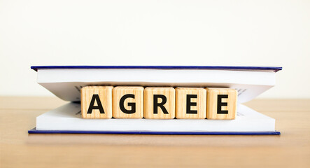 Agree symbol. Concept word Agree on beautiful wooden blocks in book. Beautiful wooden table white background. Business agree concept. Copy space.