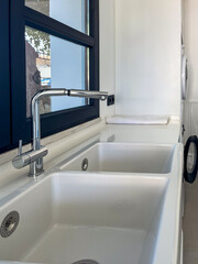 Modern loundry sink with dual basins, sleek chrome faucet, and bright natural light streaming...