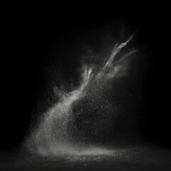 Fine white powder disperses dramatically against a black background, creating a dynamic, cloud-like shape with tiny particles suspended mid-air.