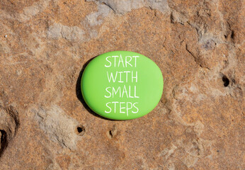 Start with small steps symbol. Concept words phrase Start with small steps on beautiful green stone. Beautiful brown stone beach background. Business Start with small steps concept. Copy space.