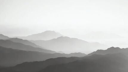 Fototapeta premium Misty mountain range with layered peaks fading into the distance under a pale, overcast sky.