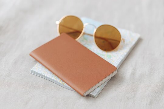 flat-lay of travel essentials passport map of java smartphone showing route and sunglasses on linen surface