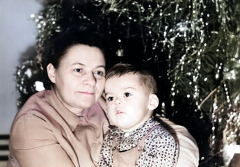 Retro portrait of a grandmother with her grandson near the New Year tree. USSR, Ukraine,...