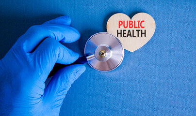 Public health symbol. Concept words Public health on beautiful wooden heart. Doctor's hand in blue medical glove. Stethoscope. Beautiful blue background Medical healthy lifestyle public health concept