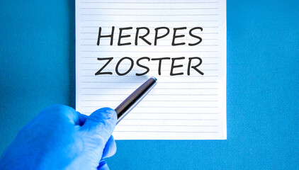 Herpes zoster symbol. Concept words Herpes zoster on beautiful white note. Doctor's hand in blue medical glove. Black pen. Beautiful blue background. Medical healthy lifestyle herpes zoster concept