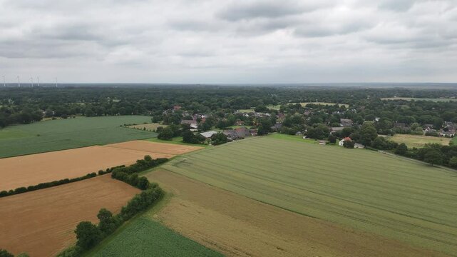 Weite norddeutsche Landschaft bei Ritterhude: gr&uuml;ne Felder, sanfte H&uuml;gel, Ackerland und Wiesen unter bew&ouml;lktem Himmel &ndash; eine b&auml;uerliche Szene im Fr&uuml;hsommer, festgehalten per Drohne.