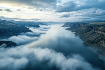 Fototapeta premium Low clouds blanket the Palisades Reservoir at dawn with a tranquil atmosphere and breathtaking views, Aerial of low clouds above the Palisades Reservoir on the Snake River in Idaho
