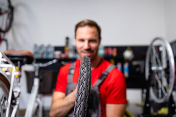Bicycle repairman replacing bike tire in workshop.