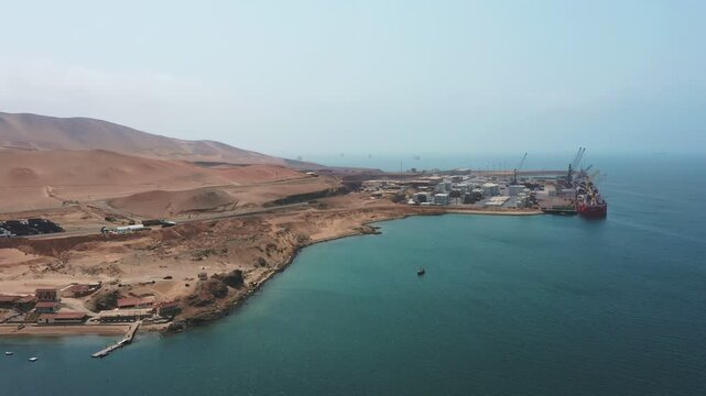 Paracas, Pisco. Peru 11 SEP 2024. A red ship is docked at a port on a beautiful day. The sky is clear and the water is calm