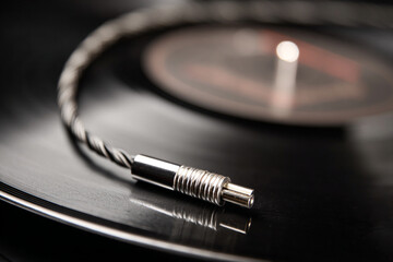 Close-up view of a vinyl record and audio cable showcasing classic music setup