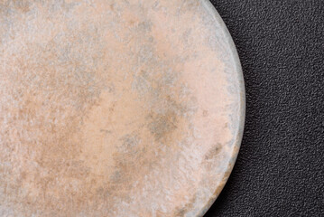 Empty round black plate for food, kitchen utensils on dining table. Empty plate