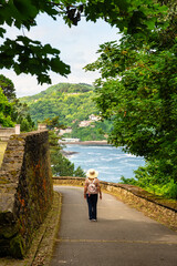 Tourist woman walking through the forest of Mount Urgull in San Sebastian, Spain.
