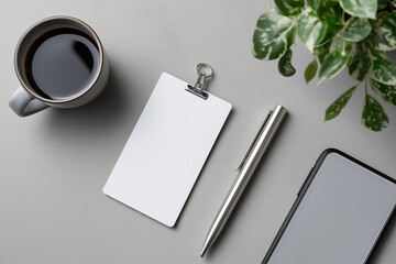 Flat lay of name tag, pen, and phone on plain grey desk