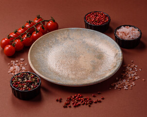 Empty round black plate for food, kitchen utensils on dining table. Empty plate