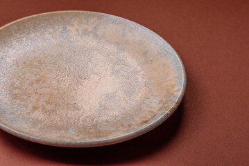 Empty round black plate for food, kitchen utensils on dining table. Empty plate
