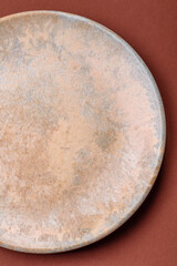 Empty round black plate for food, kitchen utensils on dining table. Empty plate