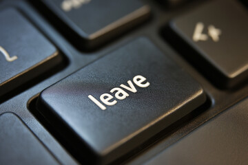 Keyboard with one key highlighted: “leave,” symbolic contrast of burnout and escape