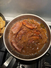 A pan of pork belly with sauce.