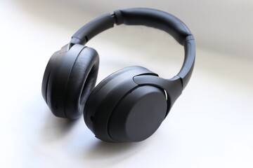 modern black wireless headphones on a white background as a symbol of mobility and technological...