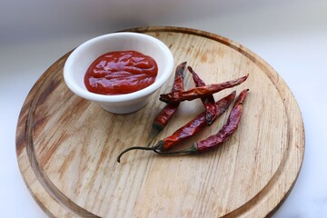 Homemade Chili Sauce and Dried Peppers on Wooden Board as a Perfect Visual Accent for Modern...