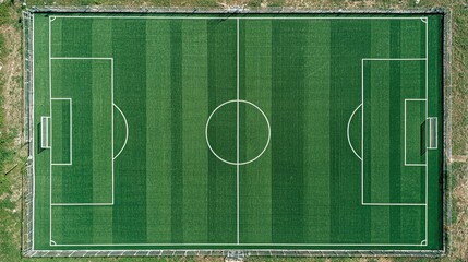 Aerial top view of empty green soccer field with clearly marked lines and freshly mowed grass