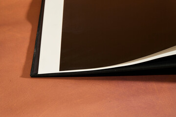 Open Hardcover Book on Brown Background
