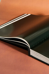 Open Hardcover Book on Brown Background
