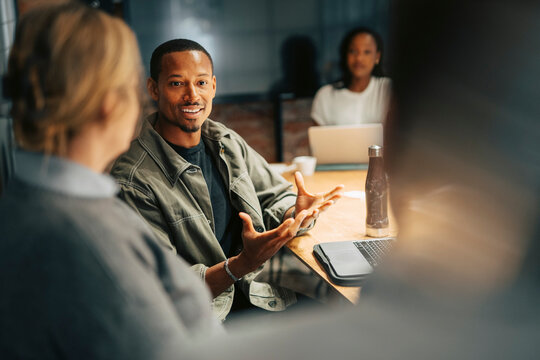 Businessman explaining strategies to colleagues in meeting at office