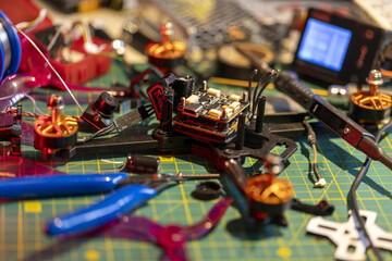 FPV drone assembly process with tools and electronic components on workspace table