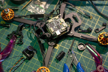 FPV drone assembly workspace with tools and components on green cutting mat