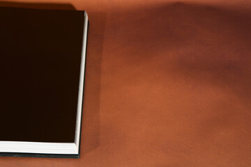 Open Hardcover Book on Brown Background
