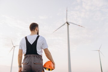 Technician looking at wind turbines in a wind farm