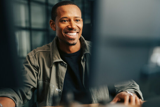 Happy businessman working on computer at office