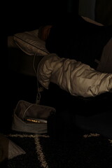 Holy Bible Book in Bag Cable Leading up to Person Lying on Bed Facing Away from Camera.