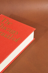 Closed Red Hardcover Book on Brown Surface
