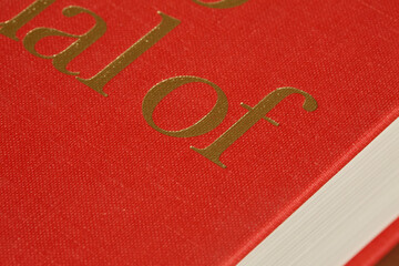 Closed Red Hardcover Book on Brown Surface
