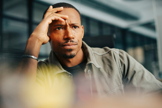 Low angle view of thoughtful businessman with head in hand at office