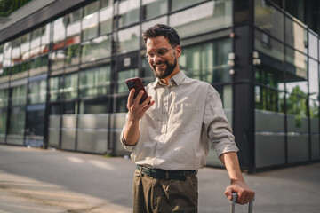 one man with beard and eyeglasses walk with suitcase and use phone