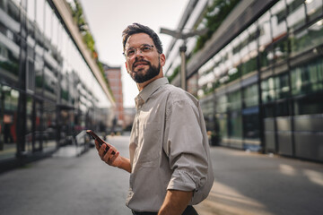 one man with beard and eyeglasses walk with suitcase and use phone