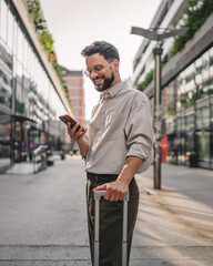 one man with beard and eyeglasses walk with suitcase and use phone