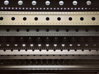 Abstract architectural design featuring layered metal beams with circular cutouts and integrated...