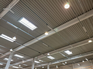 Industrial ceiling with skylights and modern lighting fixtures, showcasing a spacious interior design and innovative architectural elements