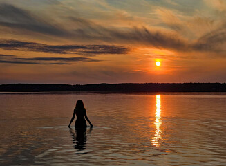wonderful view of a person bathing in the sunset in the lake